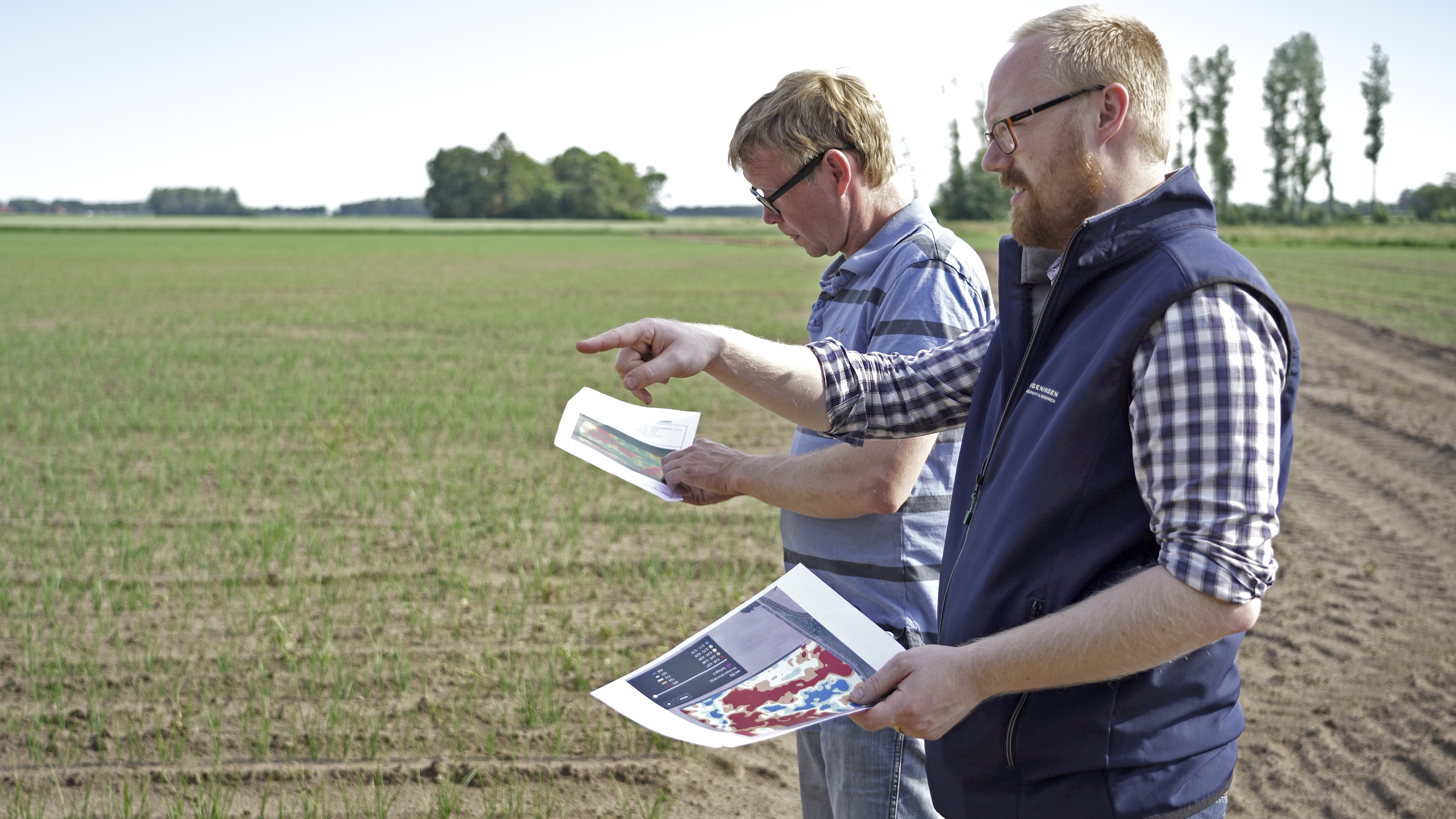 Met respectievelijk de perceelskaart met de Veris-bodemscan en de taakkaart voor bodemherbiciden in de hand zoeken WUR-expert Johan Booij (voorgrond) en Nanne Sterenborg een plek met een laag percentage organische stof (perceelsvariatie van 3,11 tot 6,07%).